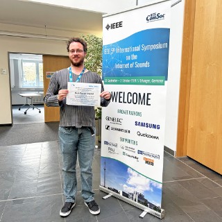 Man holds award certificate in his hand